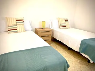 a bedroom with two beds and a nightstand between them at MyChoice Casa Milagros in Rota