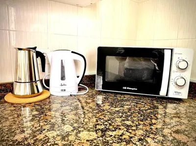 a microwave and a toaster and a blender on a counter at MyChoice Casa Milagros in Rota