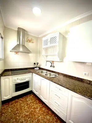 a white kitchen with a sink and a stove at MyChoice Casa Milagros in Rota