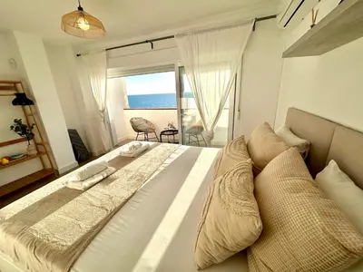 a bedroom with a bed with a view of the ocean at GATU Villa Mar 