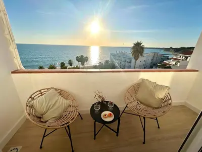 two chairs and a table on a balcony with a view of the ocean at GATU Villa Mar 