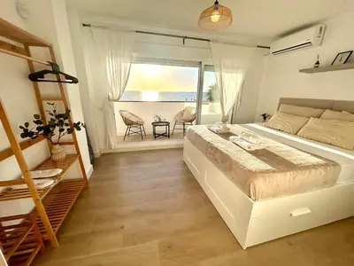 a bedroom with a large bed and a balcony at GATU Villa Mar 