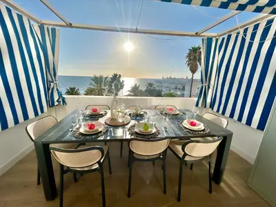 a dining room with a table and chairs and the ocean at GATU Villa Mar 