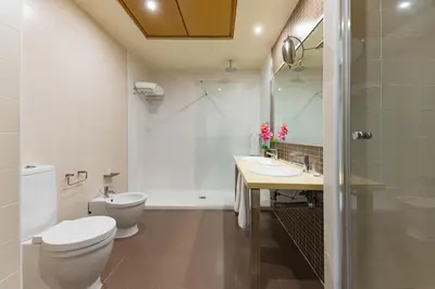 a bathroom with a toilet and a sink at Elba Costa Ballena Beach & Thalasso Resort in Costa Ballena