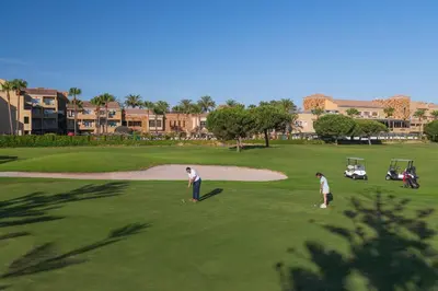 two people playing golf on a golf course at Elba Costa Ballena Beach & Thalasso Resort in Costa Ballena