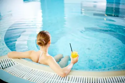 a woman in a bikini sitting on a raft next to a swimming pool at Elba Costa Ballena Beach & Thalasso Resort in Costa Ballena