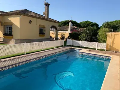 a swimming pool in front of a house at La Bilbaina con Piscina, Jardin y Parking Exclusivo 10 in Chiclana de la Frontera
