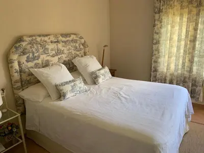 a bedroom with a bed with white sheets and pillows at La Bilbaina con Piscina, Jardin y Parking Exclusivo 10 in Chiclana de la Frontera