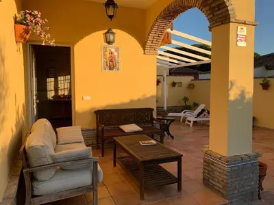 a patio with a couch and a table at La Bilbaina con Piscina, Jardin y Parking Exclusivo 10 in Chiclana de la Frontera