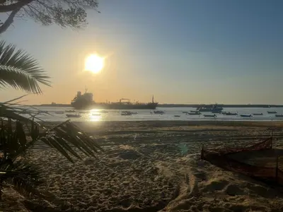 a beach with boats in the water at sunset at Mi Paraiso in Sanlúcar de Barrameda