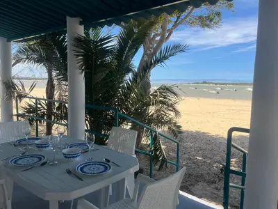 a table on a porch with a view of the beach at Mi Paraiso in Sanlúcar de Barrameda