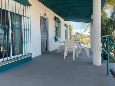 a patio with a table and chairs on a house at Mi Paraiso in Sanlúcar de Barrameda