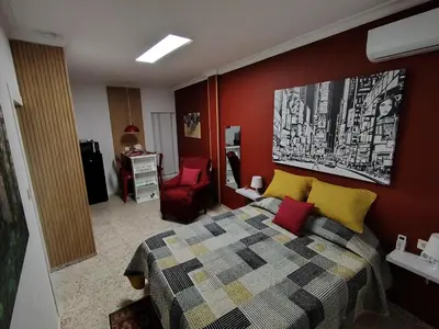 a bedroom with a bed and a red wall at Bienvenidos a San Miguel in Jerez de la Frontera
