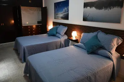 a bedroom with two beds with blue pillows at Bienvenidos a San Miguel in Jerez de la Frontera