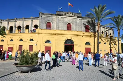 a group of people standing in front of a yellow building at Bienvenidos a San Miguel in Jerez de la Frontera