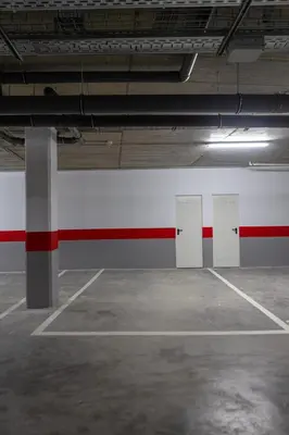 an empty parking garage with a red and white wall at AZURE - Ático dúplex in Chipiona