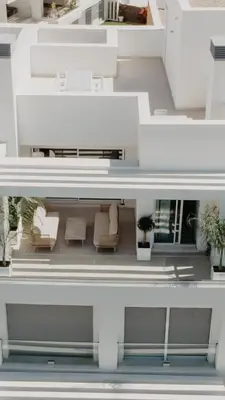 a white house with white furniture and plants at AZURE - Ático dúplex in Chipiona