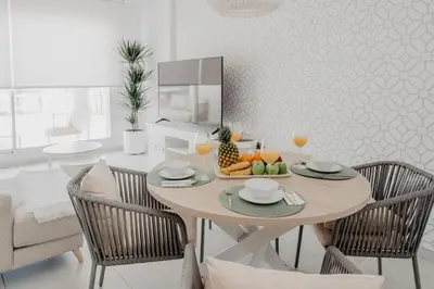 a dining room with a table and chairs with fruit on it at AZURE - Ático dúplex in Chipiona
