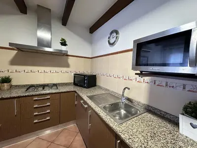 a kitchen with a sink and a flat screen tv at Casita en La Barrosa, Complejo Atlántico in Chiclana de la Frontera