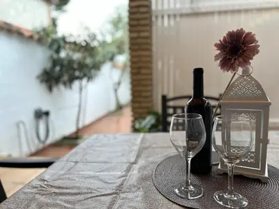 a table with a bottle of wine and two wine glasses at Casita en La Barrosa, Complejo Atlántico in Chiclana de la Frontera