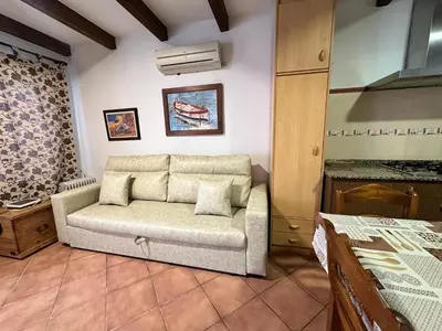 a living room with a couch and a bed at Casita en La Barrosa, Complejo Atlántico in Chiclana de la Frontera