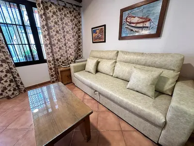 a living room with a couch and a coffee table at Casita en La Barrosa, Complejo Atlántico in Chiclana de la Frontera