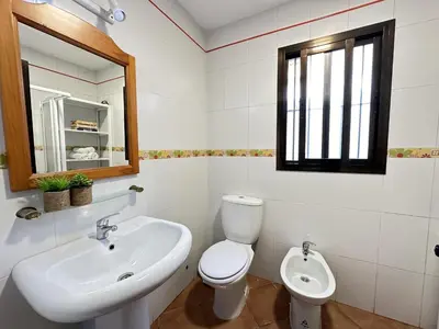 a bathroom with a sink and a toilet and a mirror at Casita en La Barrosa, Complejo Atlántico in Chiclana de la Frontera