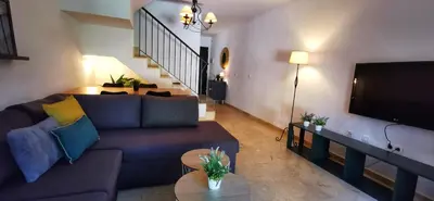 a living room with a couch and a tv at Kalma Vivienda vacacional la barrosa Chiclana Cadiz in Chiclana de la Frontera