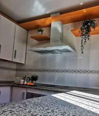 a kitchen with white cabinets and a stove top oven at Kalma Vivienda vacacional la barrosa Chiclana Cadiz in Chiclana de la Frontera