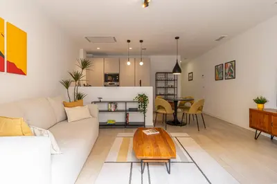a living room with a white couch and a table at Allo Apartments San Clemente Parking Piscina Centro 2 Habitaciones in Jerez de la Frontera
