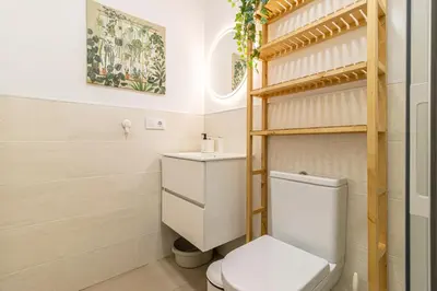 a bathroom with a toilet and a shelf at Allo Apartments San Clemente Parking Piscina Centro 2 Habitaciones in Jerez de la Frontera