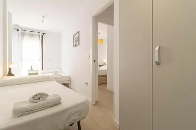 a white room with two beds and a walk in shower at Allo Apartments San Clemente Parking Piscina Centro 2 Habitaciones in Jerez de la Frontera