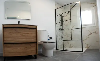 a bathroom with a toilet and a glass shower at Domus Gades in Chiclana de la Frontera