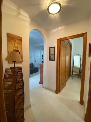 a living room with a hallway with a table and a lamp at Apartamento a pie de playa in Rota