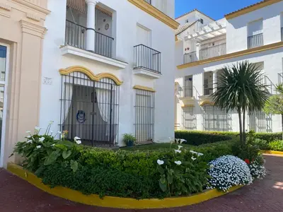 a building with flowers in front of it at Apartamento a pie de playa in Rota