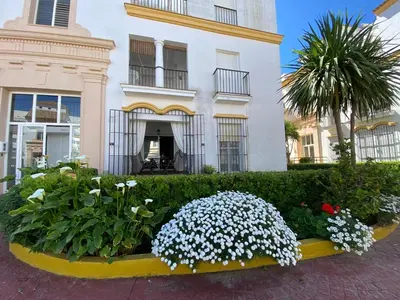 a flower garden in front of a building at Apartamento a pie de playa in Rota