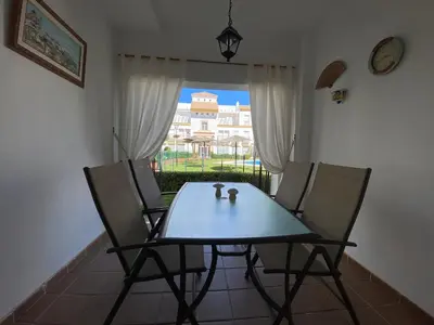 a table and chairs in a room with a window at Apartamento a pie de playa in Rota