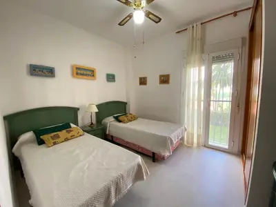 a bedroom with two beds and a window at Apartamento a pie de playa in Rota