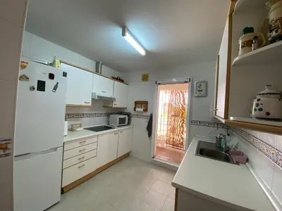 a kitchen with a white refrigerator and a sink at Apartamento a pie de playa in Rota