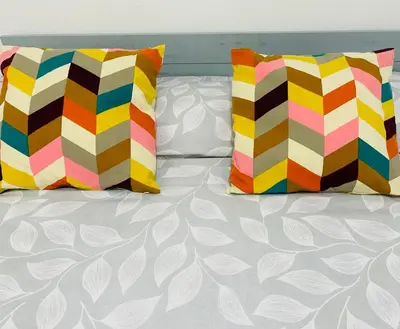 a bed with two colorful pillows on it at SOTAVENTO Salmarina in Sanlúcar de Barrameda