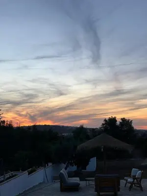 a sunset over a patio with chairs and an umbrella at Casa Santos Arcos vistas y parking privado in Arcos de la Frontera