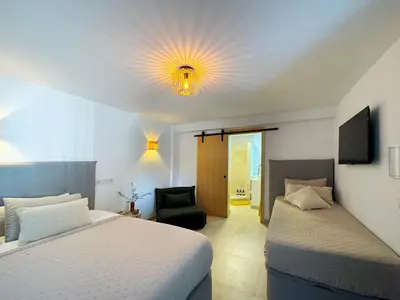 a bedroom with two beds and a television on the ceiling at Casa Santos Arcos vistas y parking privado in Arcos de la Frontera