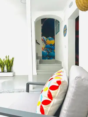 a living room with a white couch with a pillow at Sotavento Malandar in Sanlúcar de Barrameda