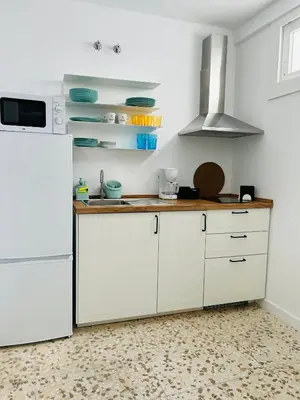 a kitchen with white cabinets and a white refrigerator at Sotavento Malandar in Sanlúcar de Barrameda