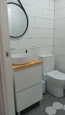 a bathroom with a sink and a toilet and a mirror at Apartamento, Plaza las Infantas in Sanlúcar de Barrameda