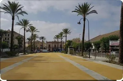 an empty street with palm trees and a building at Apartamento, Plaza las Infantas in Sanlúcar de Barrameda
