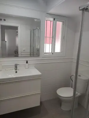 a bathroom with a toilet and a sink and a mirror at CHICLANA&DISFRUTA in Chiclana de la Frontera
