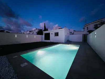 a swimming pool in a backyard at night at CHICLANA&DISFRUTA in Chiclana de la Frontera