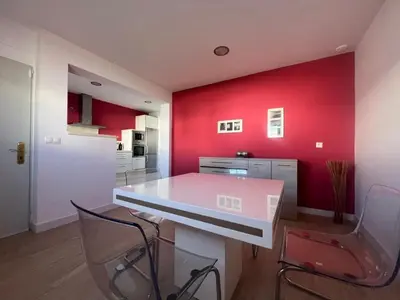 a kitchen with red walls and a white table and chairs at CHICLANA&DISFRUTA in Chiclana de la Frontera