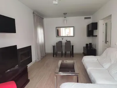 a living room with a white couch and a table at CHICLANA&DISFRUTA in Chiclana de la Frontera
